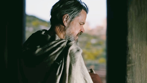 Schermo cinematografico luminoso che mostra titoli di film in uscita con dati di incasso numerico, immagine di approfondimento